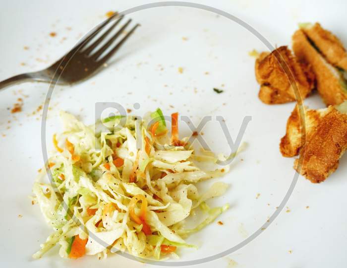 leftover food and fork on white plate