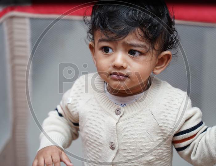 Closeup Photo Of An Adorable Baby Indian Boy With Worried Face