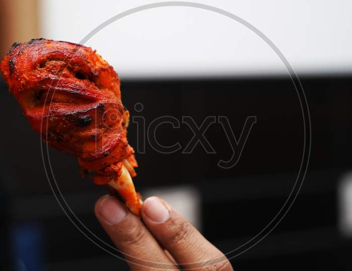 Close Up Image Of A Piece Of Fried And Roasted Chicken Tandoori Leg Piece.Its A Spicy North Indian Starter Dish