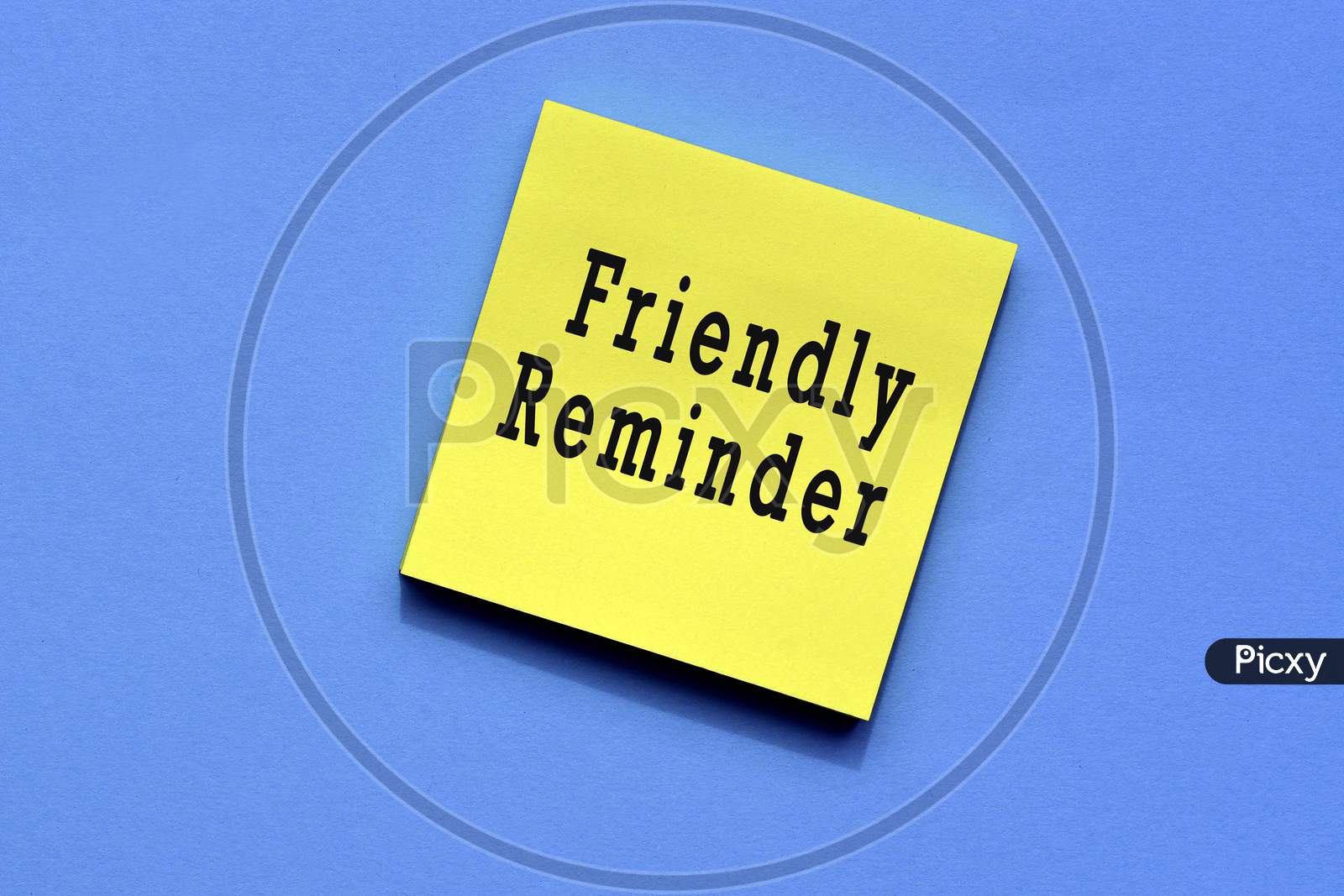reminder text on yellow sticky note with blue background
