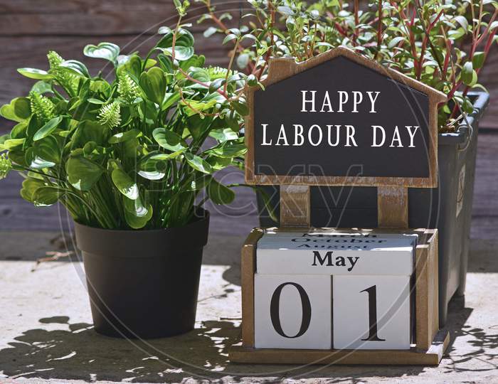Text on chalkboard and white cube block with plant background in the garden - Happy Labour Day