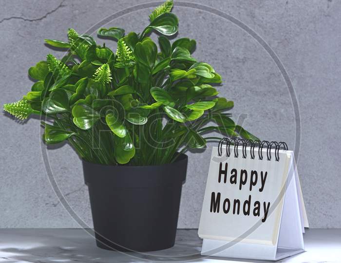 Text on notepad with green plant background - Happy Monday