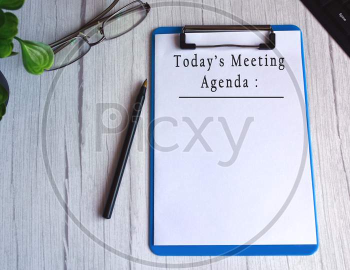 Today's meeting agenda text on blue clip board. Meeting goals concept