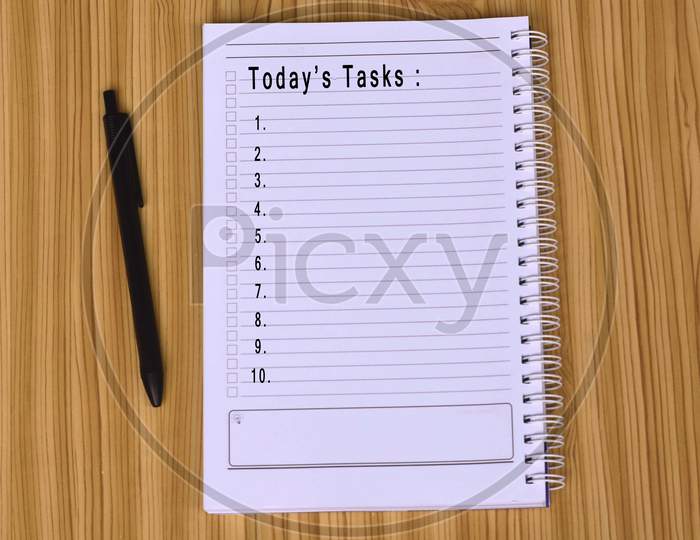 Text on notepad with laptop and smartphone on wooden table. Work habit concept