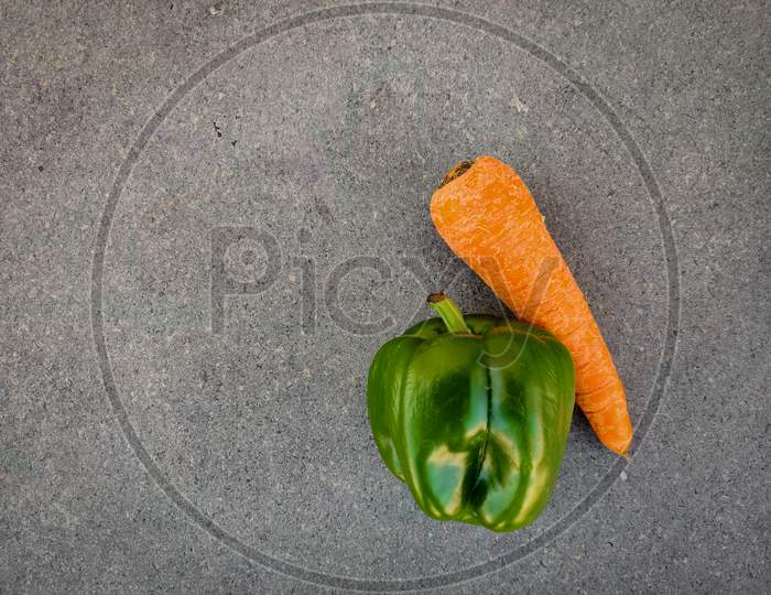 Top View Of Green Capsicum And Carrot Isolated On Grey Background