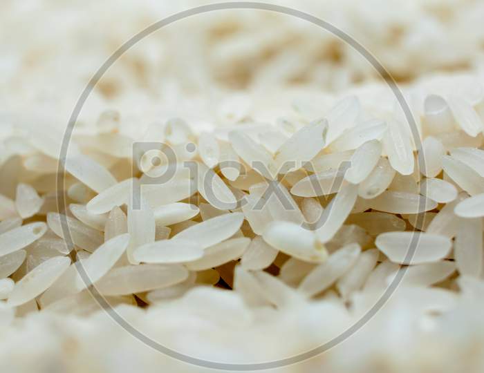 Close Up Of Uncooked White Rice Grains With Selective Focus.