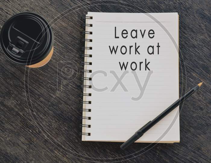 Motivational and inspirational quote on notepad with disposable coffee cup and pen on wooden table