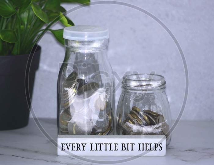Text on wood block with Australian and European coins on table surface with plant background - Help others in need. Charity concept