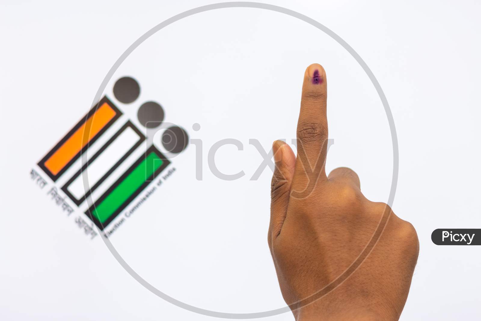 Indian Voter Hand With Voting Sign And Ink Pointing Vote For India Behind On Election Commission Of India Background.