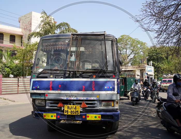 City Space Indian Bus Closeup. Traffic Bus Runs On Road With Motorbike Riders In Background.