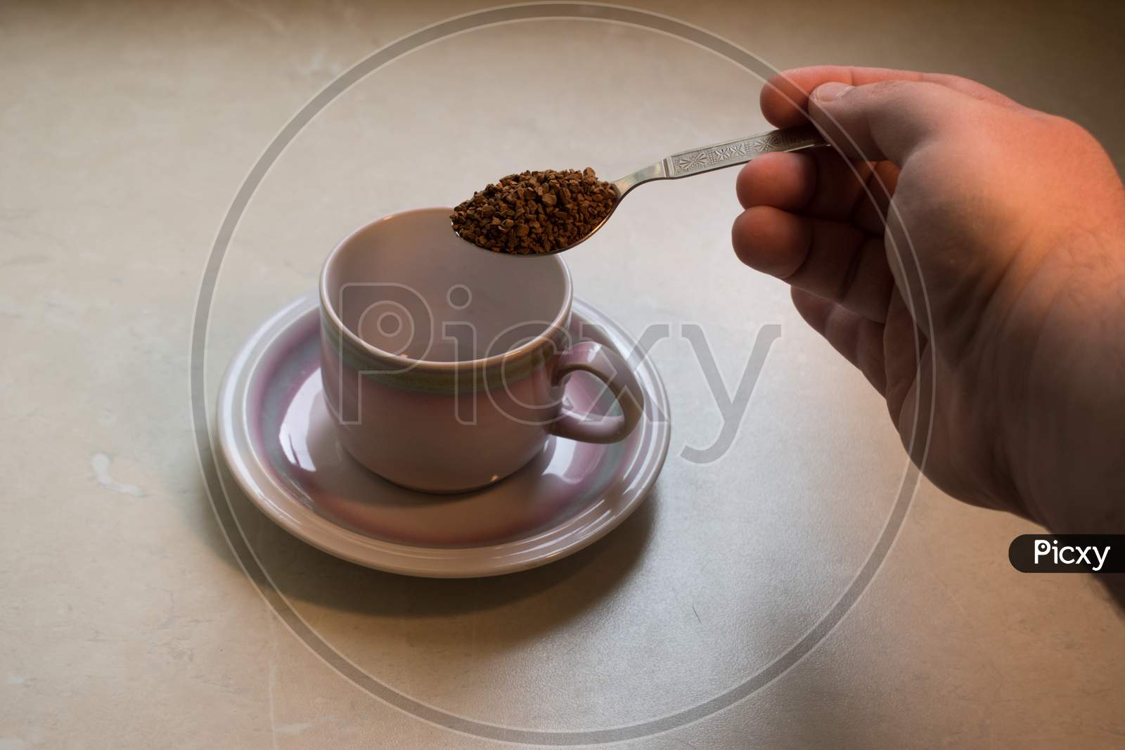 The Preparation Of Soluble Coffee. Freeze-Dried Coffee In A Spoon Over A Cup On Plate.