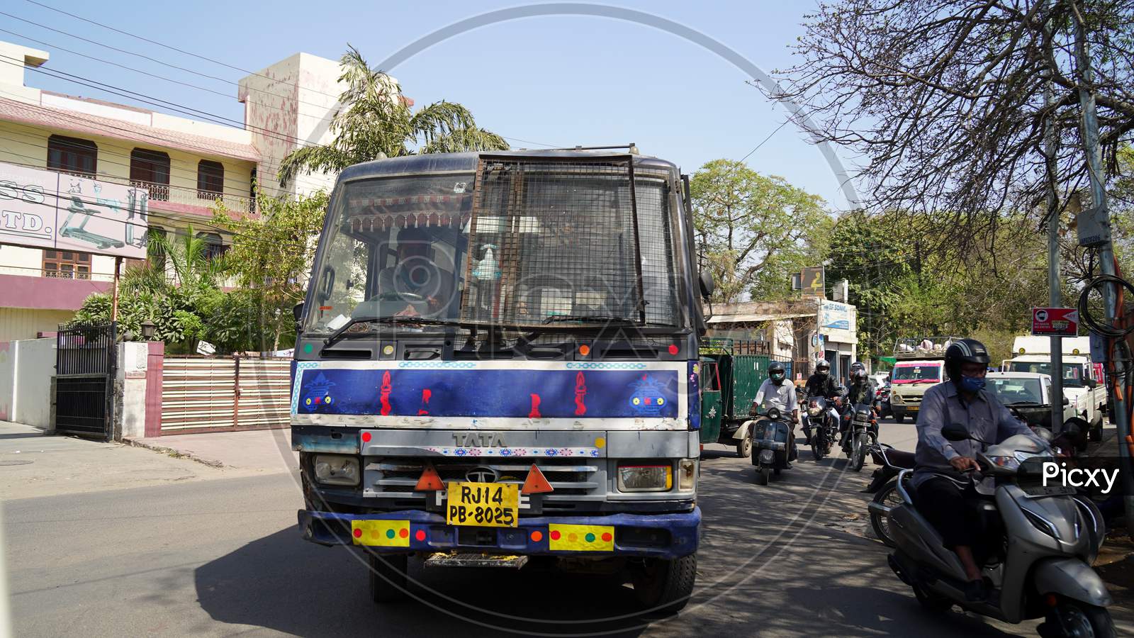 City Space Indian Bus Closeup. Traffic Bus Runs On Road With Motorbike Riders In Background.