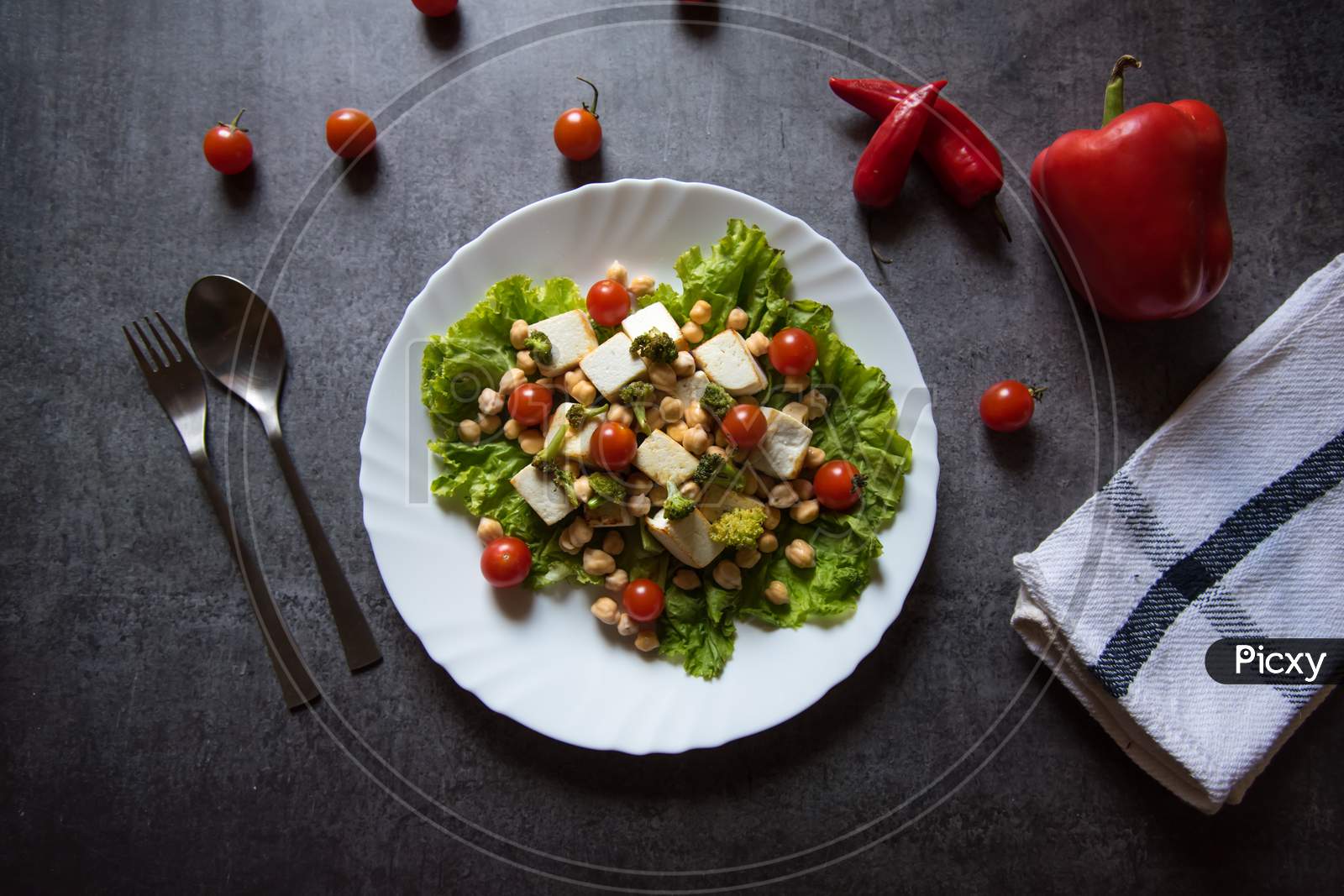Chicken chick peas and cherry tomato salad on a white plate with use of selective focus