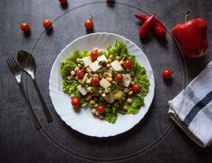 Chicken chick peas and cherry tomato salad on a white plate with use of selective focus