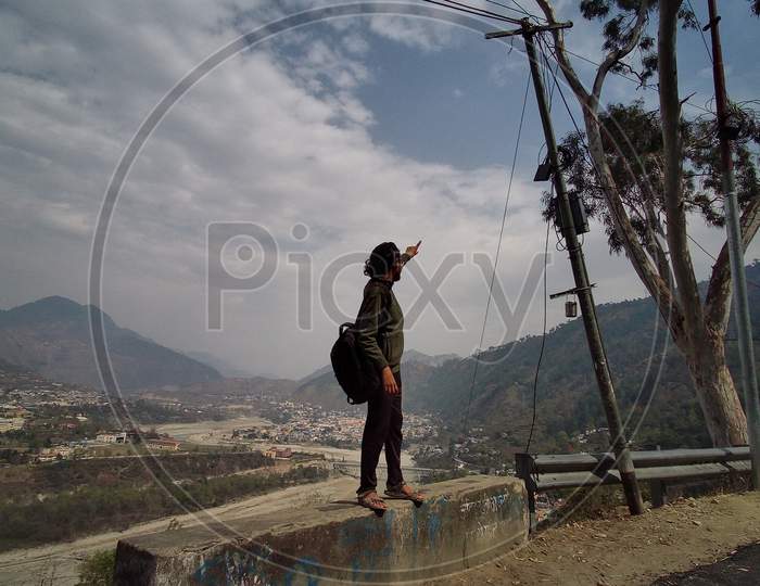 a boy at the hill station looking around the mountains