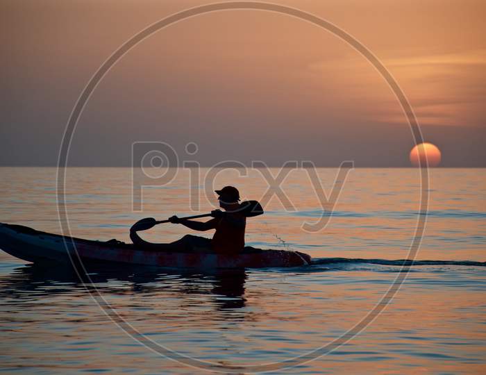 Man Boating under the Setting Sun