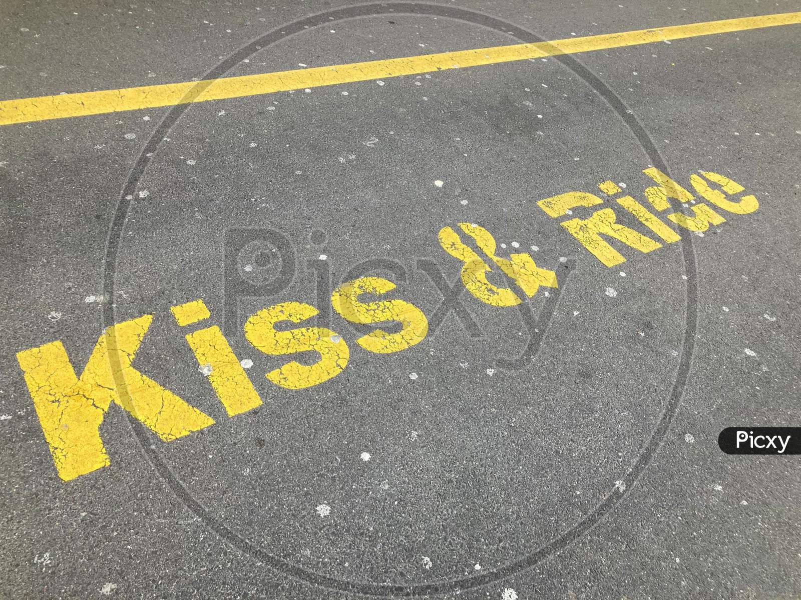 Yellow Kiss And Ride Inscription Painted On Asphalt