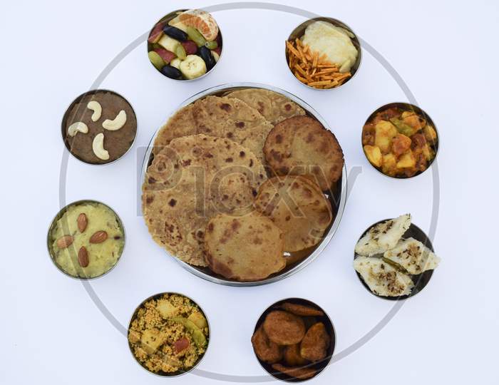 Indian Fasting Cuisine Upwas Items Thali Complere Meal For Vrat Ekadashi.Upawas Thali Meal With Rajgira Puri, Paratha,Shakarkand Halwa,Alu Sabji,Amaranth Sheera Pakoda, Sabudana Ata Dhokla, Chips