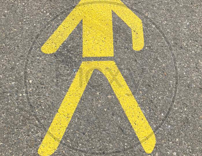 Yellow Painted Pedestrian Sign On Asphalt In Switzerland