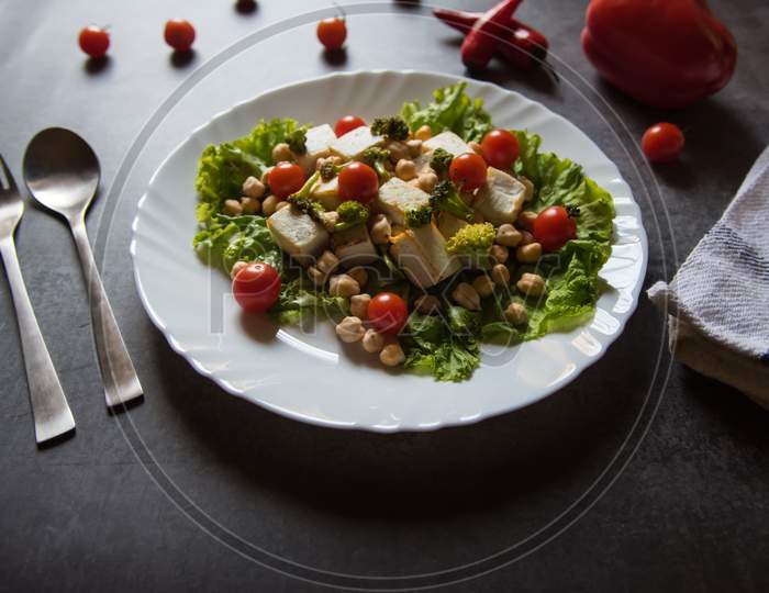 Close up of Chick peas and vegetable salad with cheese in a plate