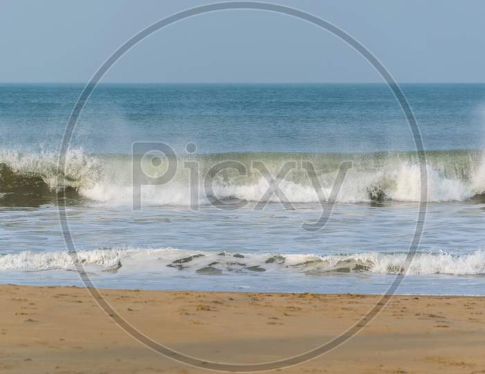 Panoramic Landscape View Of Large Foamy Sea Wave From Arabian Sea Splashing With Spray Of Water Droplets In The Air At Gokarna Situated On The West Coast, Karnataka, India.