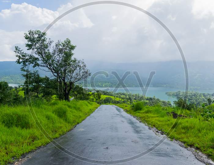 Panoramic Landscape View Of A Rural Road With Lush Green Foliage On Both Sides On A Monsoon Day, Going Downhill To Tapola Village Of Satara, Maharashtra, India