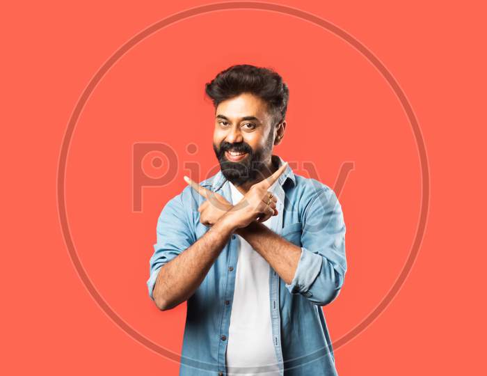 Indian Asian Bearded Man Pointing Or Advertising Blank Space Against Red Background