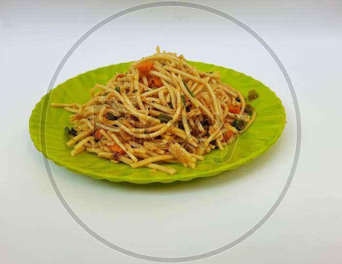 Heap of a yummy homemade noodles in a green plate isolated on white background