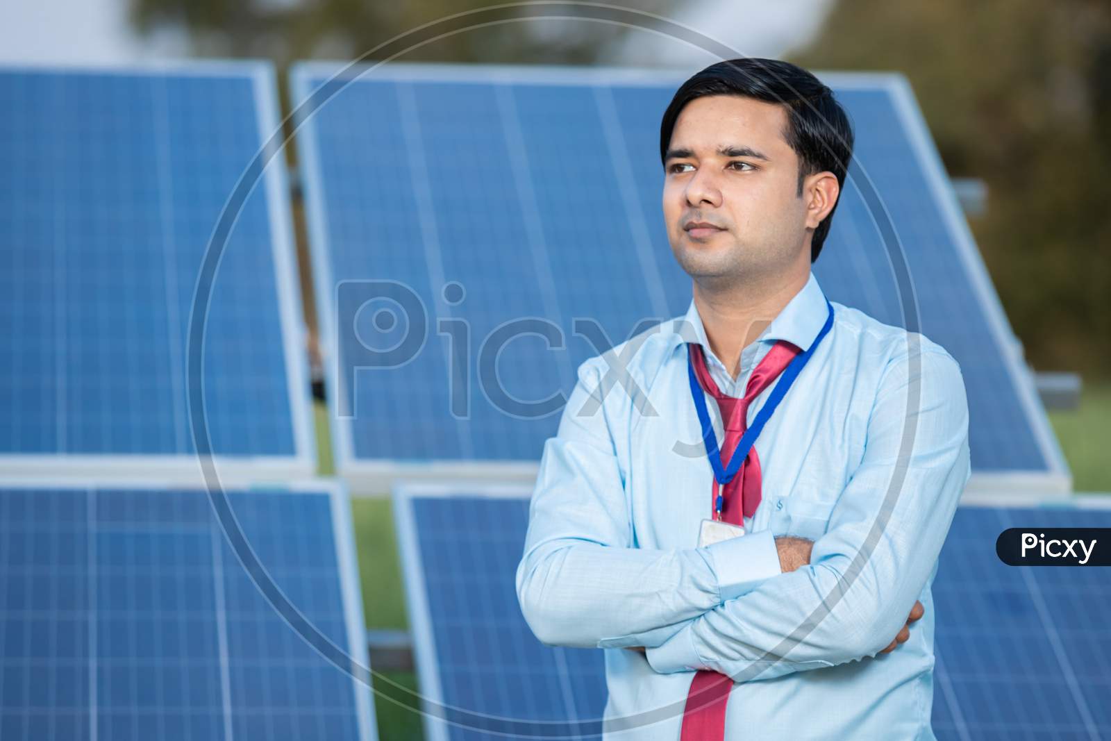 Portrait Young Indian Technician Or Manager Wearing Formal Cloths Standing With Solar Panel. Renewable Energy, Man Standing Crossed Arm, Copy Space.