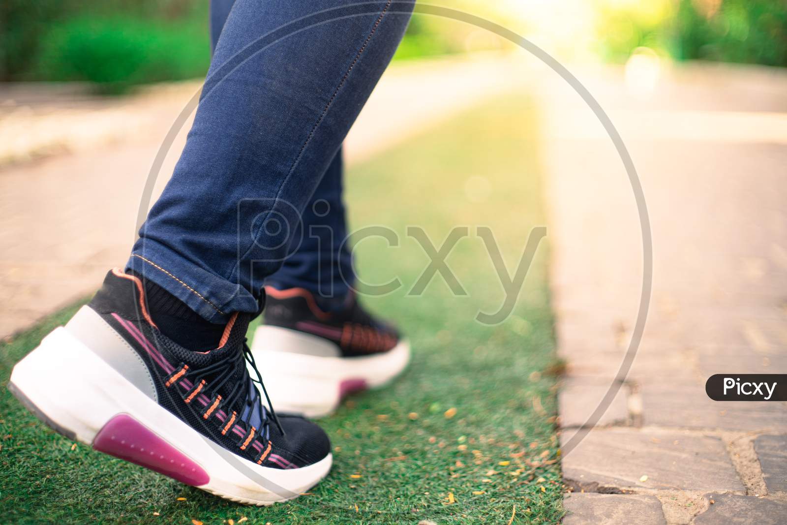 Low Macro Shot Showing Colorful Shoes Of Strong Independent Powerful Girl Going Into Sunlight While Jogging Walking For Fitness And Health. Shows Progress, Achievement, Growth And Evolution