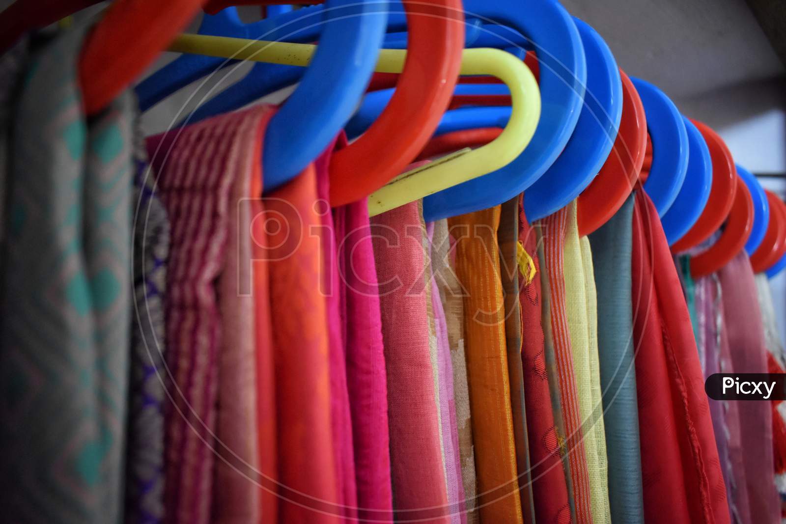 Closeup View Of Saris Or Sarees Hung On Hangers In Display Of Retail Shop,India Culture And Tradition.