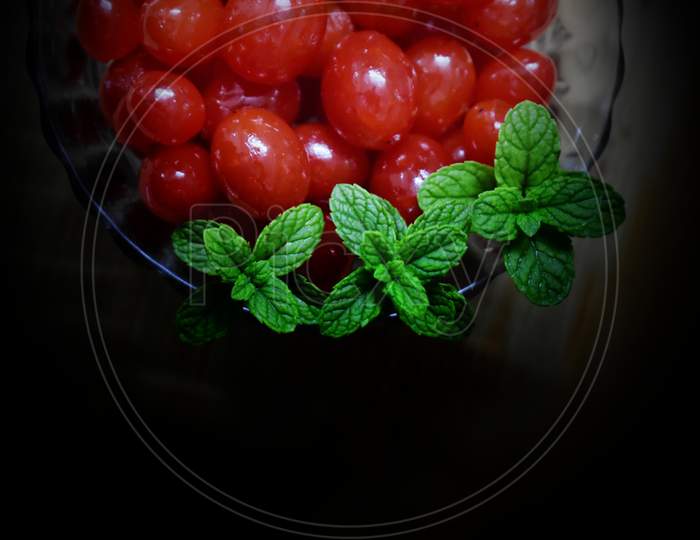 Fresh Sweet Cherries Bowl With Leaves In Water Drops On Black Background, Top View