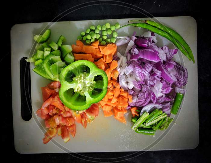 Copped Vegetables Ingredients For Tasty Vegetarian Stir Fry Dishes On Wooden Cutting Board With Knife And Chopsticks, Top View. Asian Cuisine. Healthy Eating And Food Concept