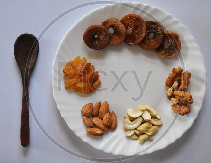 With Mixed Nuts On White Table Top View. Healthy Food And Snack. Walnut, Pistachios, Almonds, Hazelnuts And Cashews.