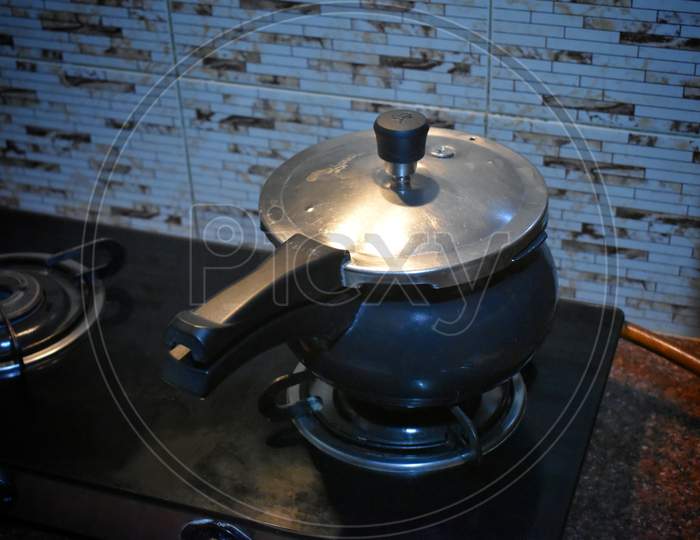 High Pressure Aluminum Cooking Pot With Safety Cover An Image Isolated On Stove,India.