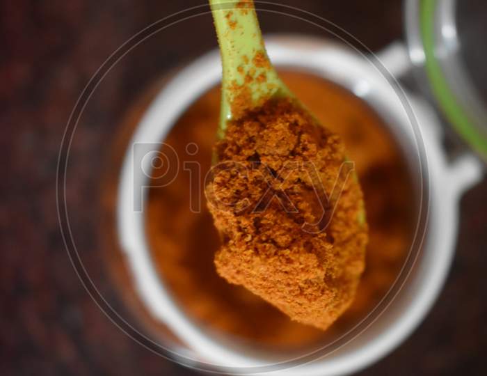 Top View Of Heap Of Red Chilli Pepper Powder In A Glass Bowl Isolated On White Background.