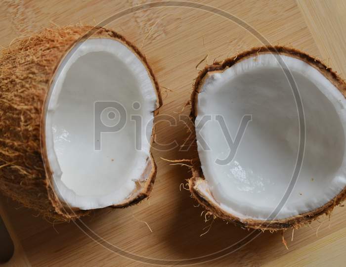 Ripe Half Cut Coconut On A Wooden Background. Coconut Cream And Oil.