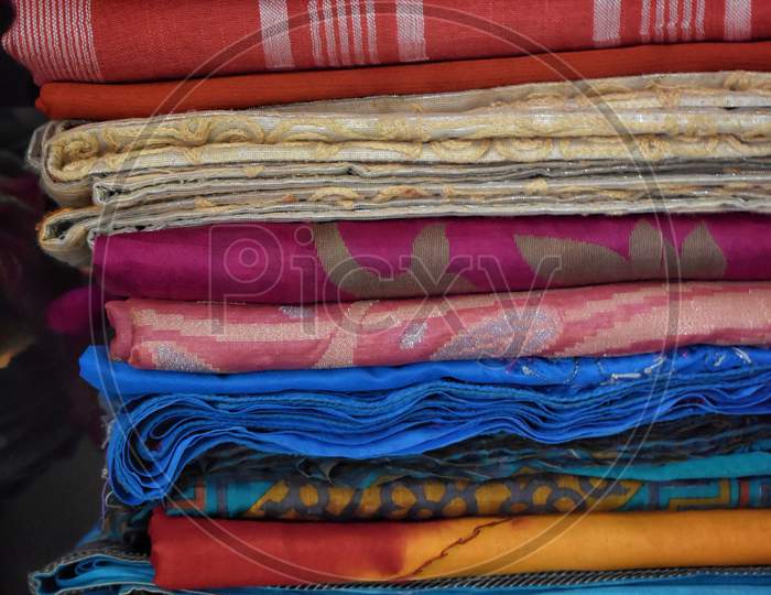 Closeup View Of Saris Or Sarees Hung On Hangers In Display Of Retail Shop,India Culture And Tradition.