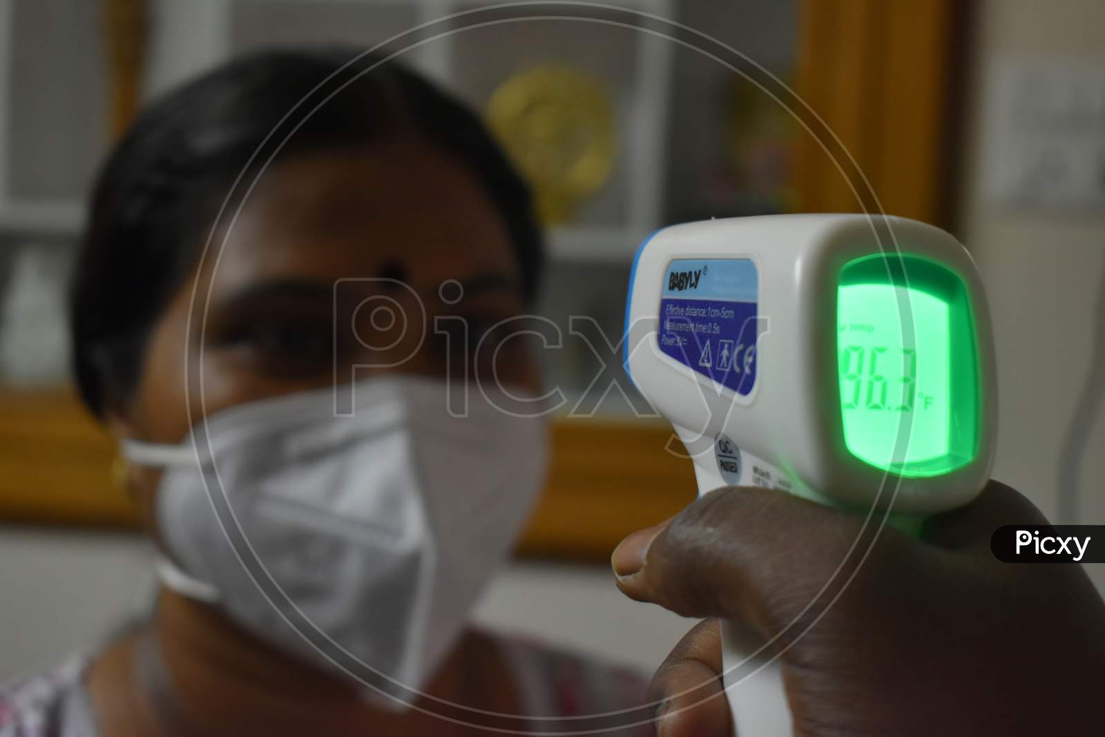Old Asian Woman Wearing N95 Mask, Getting Her Temperature Check - Health Concept,India.