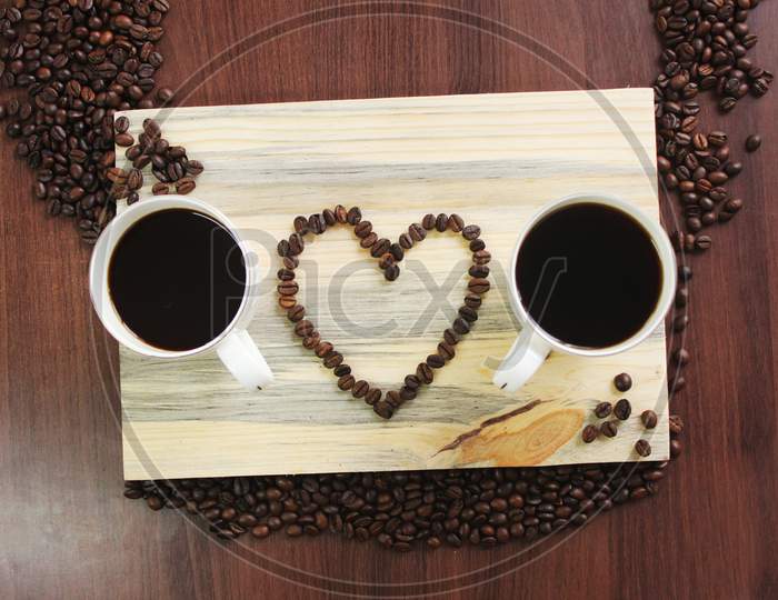Two Coffee Cup And A Heart Sign With Beans