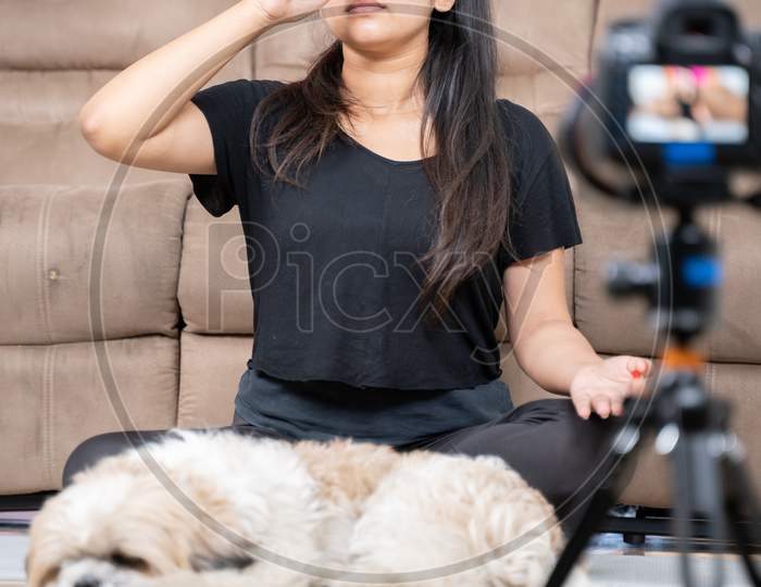 Young Girl Recording Video While Doing Nasal Breathing Exercise - Concept Of Vlogging, Online Yoga Trainer Teaching From Home Due To Coronavirus Or Covid-19 Pandemic.