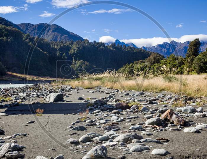 Countless Rocks Strewn Along The Okarito River In New Zealand