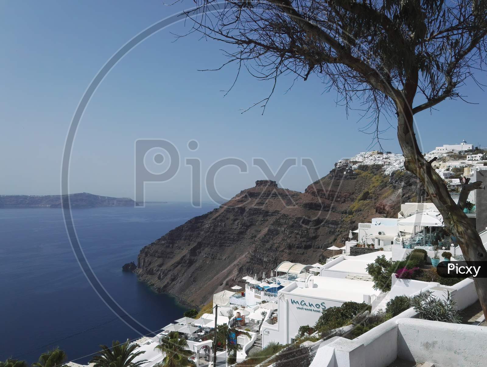 Santorini Sea View. Blue Sea, Sky And White Houses On Coastline Against Red Volcanic Mountain