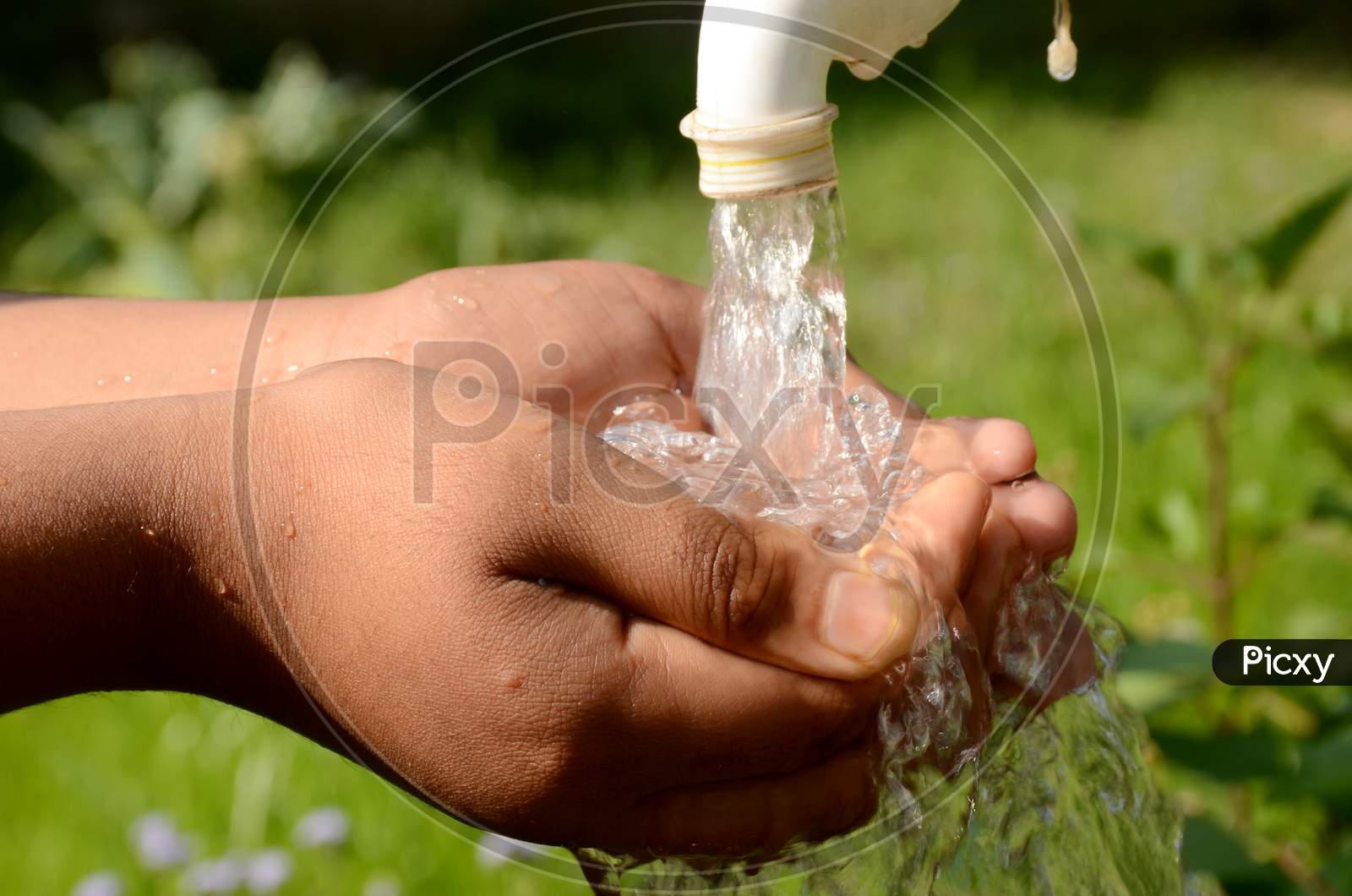 The White Tap Water With Hand Concept World Water Day Over Out Focus Green Background.