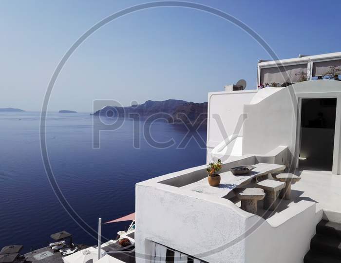 Outdoor House Terrace Roof With Wooden Vintage Table And Stool With Sea View Against Mountains Island In Santorini, Greece. Beautiful Balcony In Restaurant, Wooden Design. Nobody.