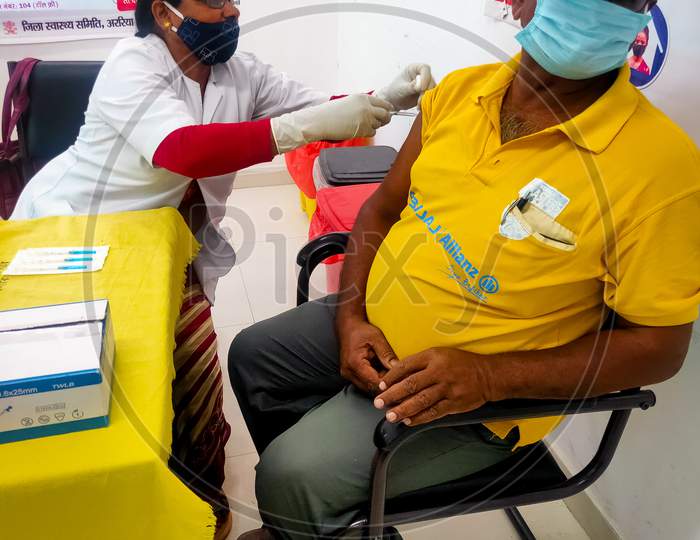 Araria-Bihar-India-03-30-2021- Woman Doctor Or Nurse Giving Syringe Vaccine, Inject Shot To Bajaj Allianz Male Staff Or Worker. Life Insurance Staff Vaccination