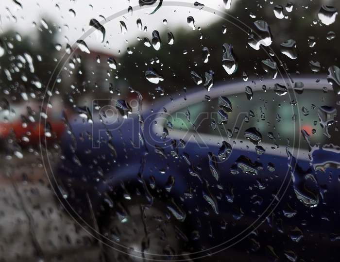 Street, Traffic, Car, Rain Drops On Driver'S Side Window, View Through Car Window Of Car During Rainy Season Formed Abstract Pattern From Water Droplets.