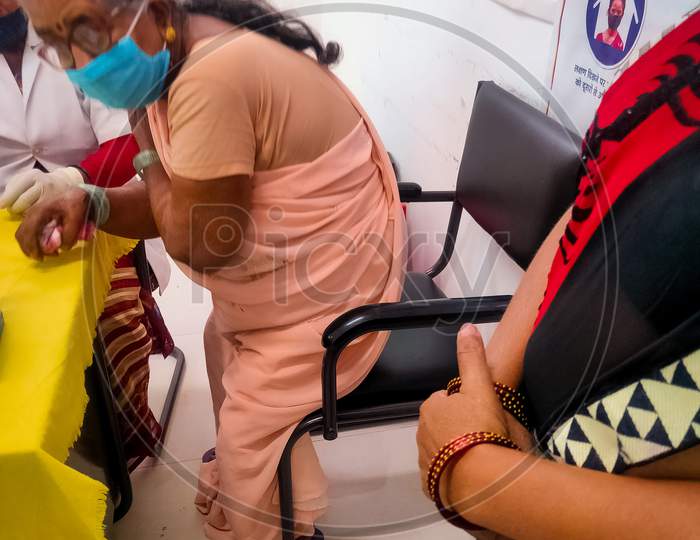 Araria-Bihar-India-03-30-2021- Woman Doctor Or Nurse Giving Syringe Vaccine, Inject Shot To Arm Old Lady Patient. Vaccination, Immunization Or Disease Prevention Against Flu Or Virus Pandemic Concept.