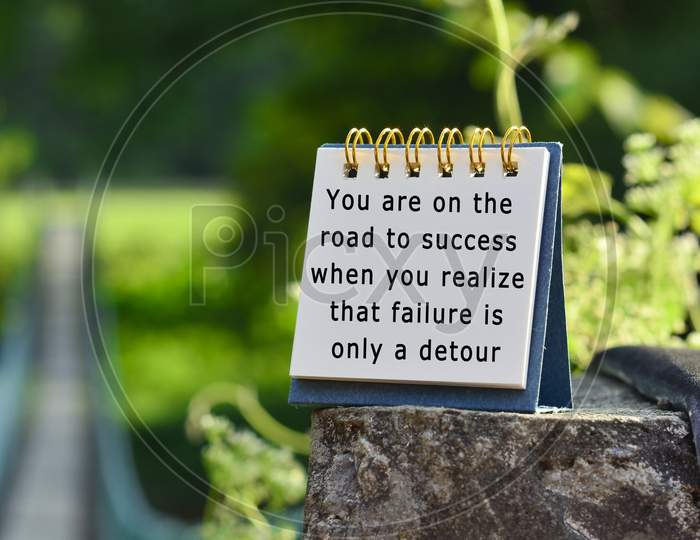 Motivational Quote On White Note With Blurred Background Of Hanging Bridge