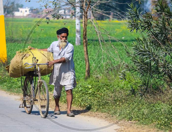 A farmer riding on a bicycle while working in his fields
